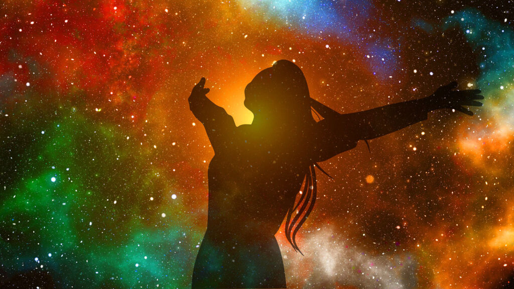 Silhouette of a person with arms outstretched against a colorful cosmic background.