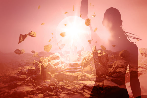 Sunlight shines through a rocky landscape with a translucent silhouette of a person.